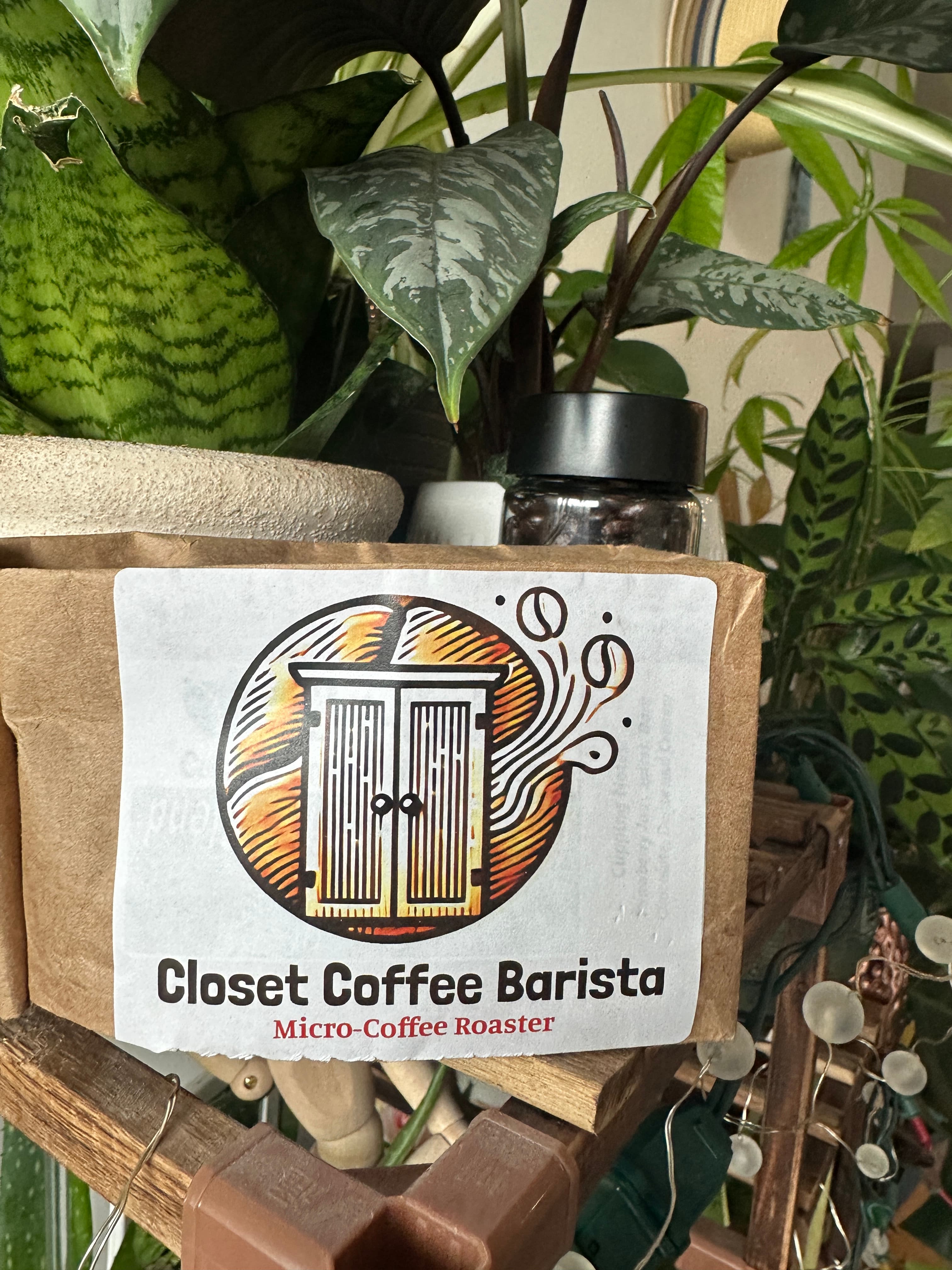 Closet Coffee Barista 12oz coffee bag with logo, surrounded by green plants