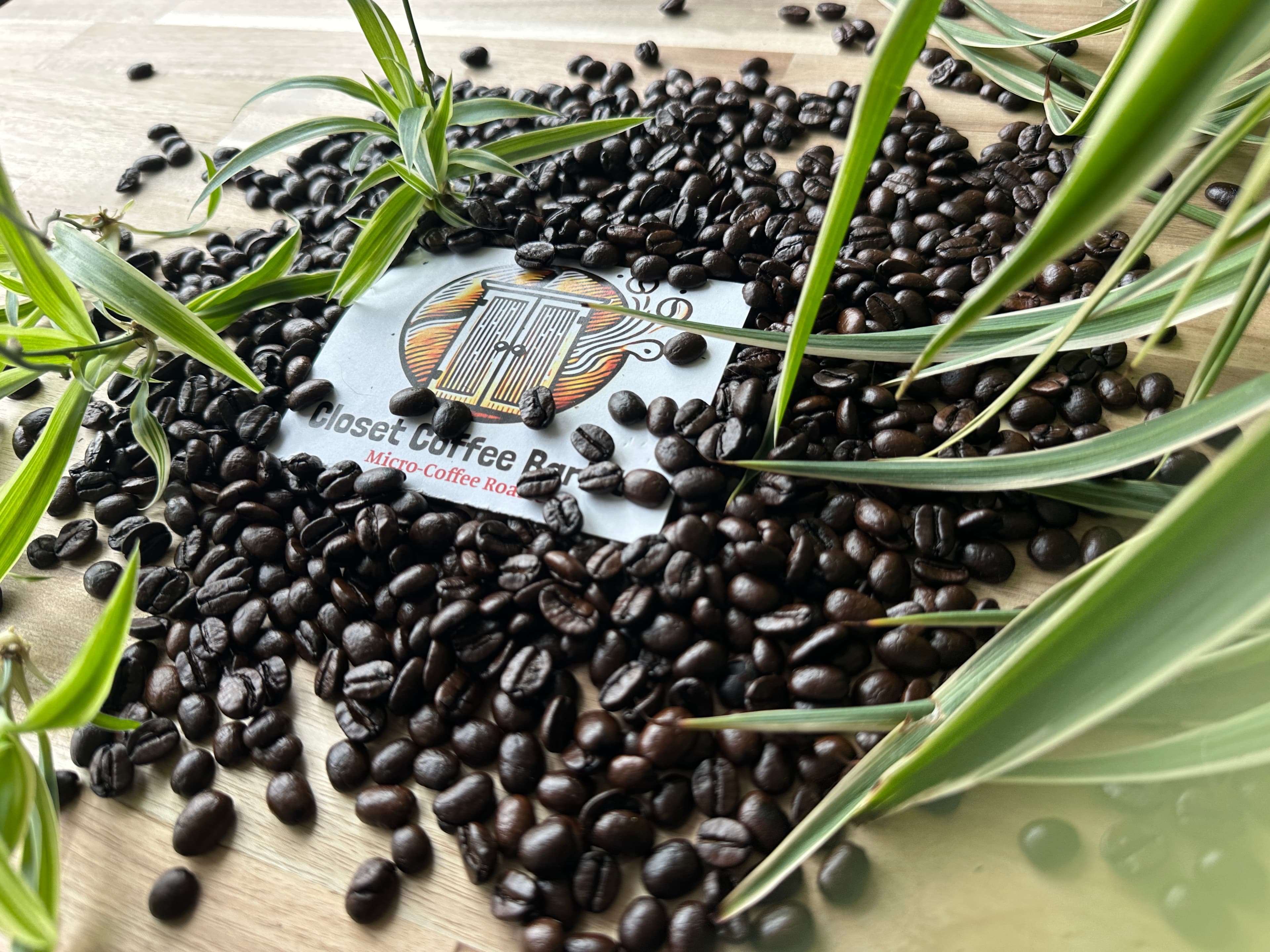 Coffee beans scattered around Closet Coffee Barista logo, representing single origin delight